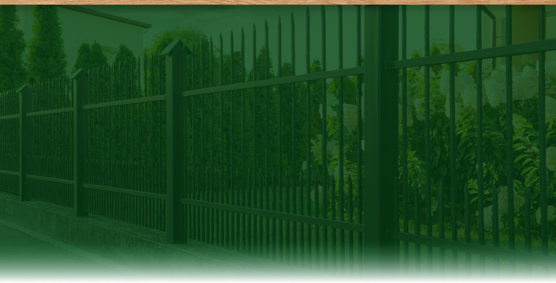 A narrow side yard beside a house with a concrete walkway and a wooden privacy fence, with a detached fence panel leaning against the fence.