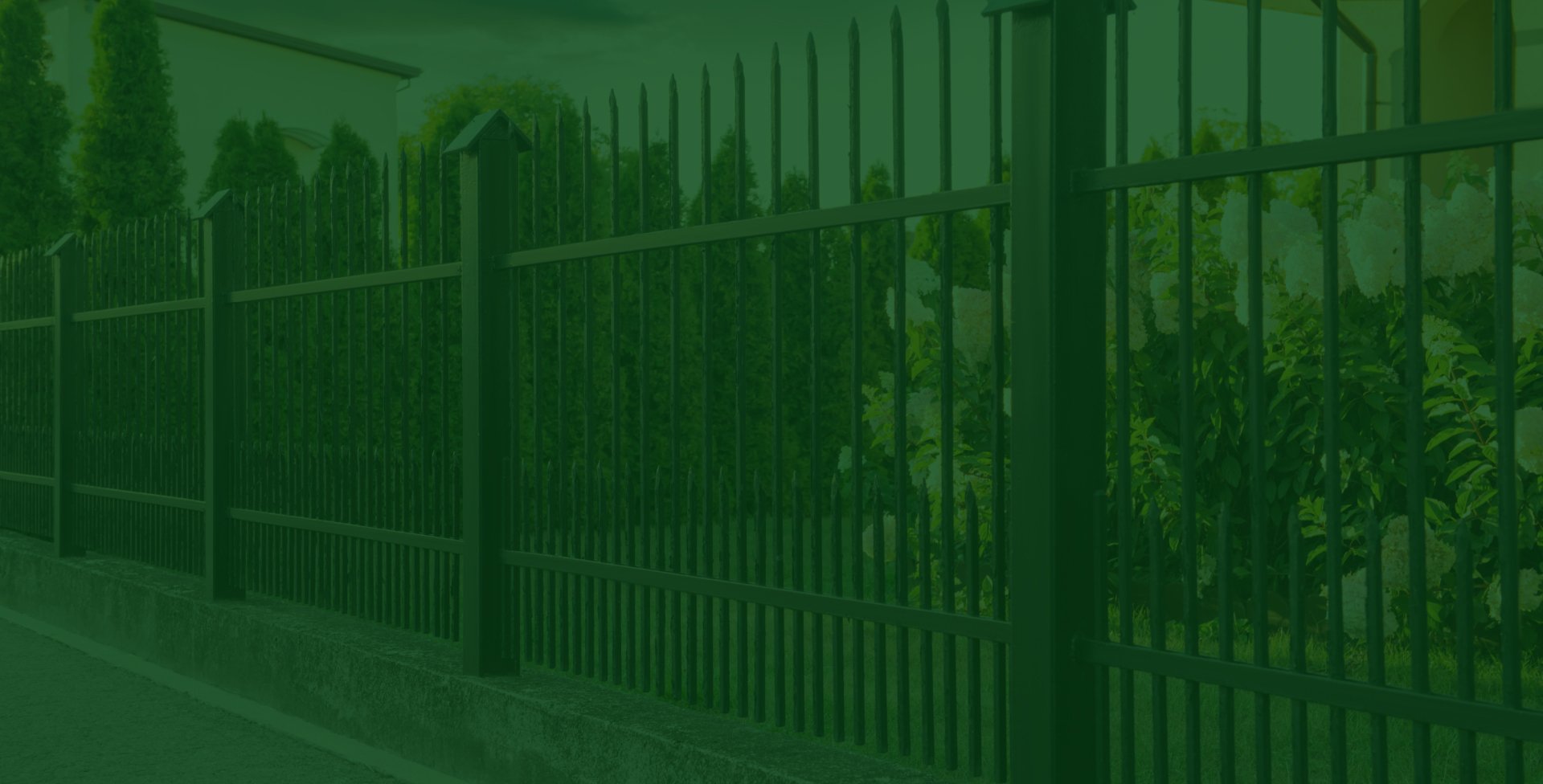 A narrow side yard beside a house with a concrete walkway and a wooden privacy fence, with a detached fence panel leaning against the fence.